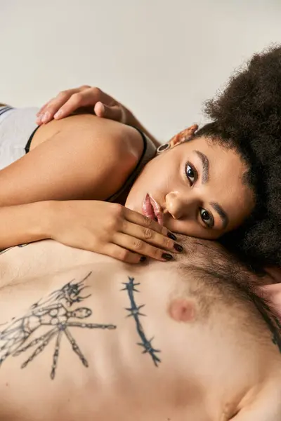 Séduisante jeune femme afro-américaine couchée sur le sol avec son petit ami, couple sexy — Photo de stock