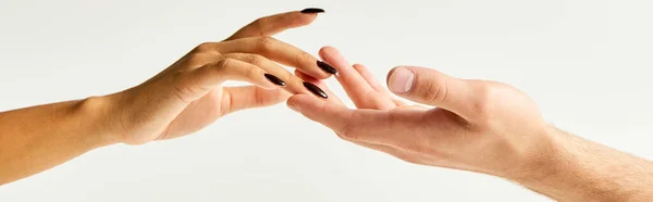 Cropped view of young couple touching hands and fingers of each other on ecru background, banner — Stock Photo