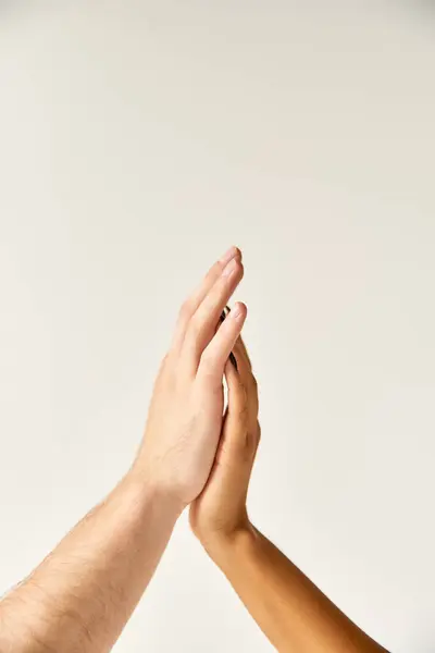 Cropped view of interracial sexy couple touching hands and fingers of each other on ecru background — Stock Photo