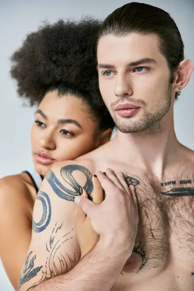 Hermosa africana americana mujer abrazando su tatuado joven novio por detrás, sexy pareja - foto de stock