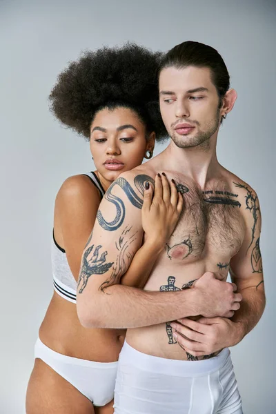 Atraente mulher afro-americana abraçando calorosamente seu namorado bonito por trás, casal sexy — Fotografia de Stock