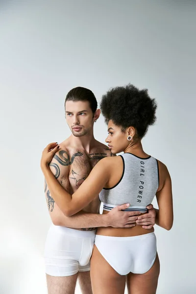Back view of attractive african american woman hugging her young tattooed boyfriend, sexy couple — Stock Photo