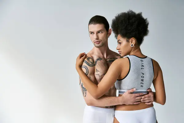 Back view of appealing african american woman hugging her young tattooed boyfriend, sexy couple — Stock Photo