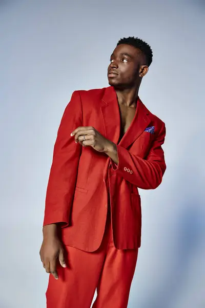 Bonito homem afro-americano com estilo elegante posando no fundo cinza, conceito de moda — Fotografia de Stock