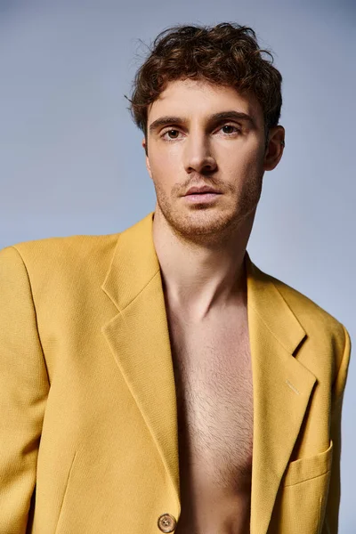 Jovem atraente na jaqueta amarela na moda posando atrativamente no fundo cinza, conceito de moda — Fotografia de Stock