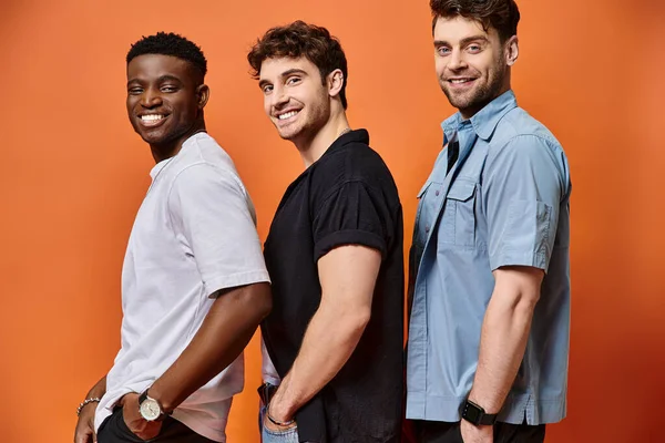 Happy multicultural stylish friends in street wear smiling joyfully at camera, fashion concept — Stock Photo