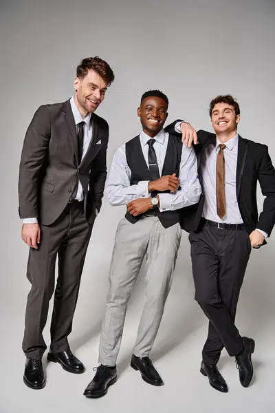 Cheerful good looking multicultural friends in business casual outfits smiling and having great time — Stock Photo