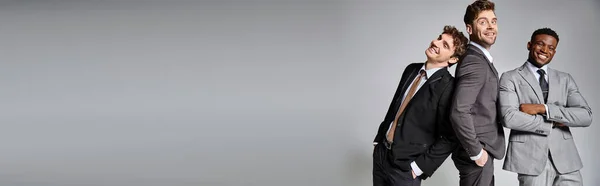 Allegri amici diversi in abiti business casual in posa su sfondo grigio e sorridente felicemente, banner — Foto stock