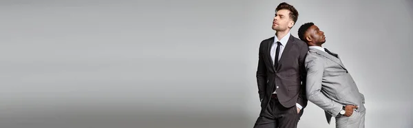 Two handsome multicultural male models in business smart attires posing on gray backdrop, banner — Stock Photo
