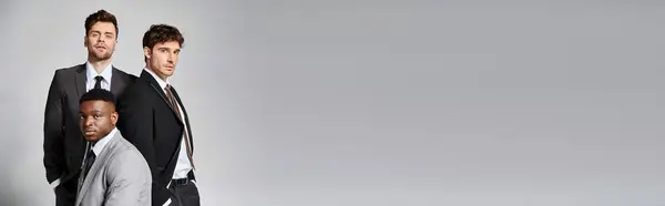 Bello diversi amici in abiti da lavoro intelligenti in posa insieme su sfondo grigio, banner — Foto stock