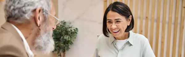 Happy middle aged woman smiling near bearded realtor in real estate office, banner — Stock Photo