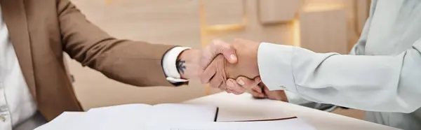 Cropped shot of woman shaking hands with middle aged realtor in real estate office, deal banner — Stock Photo