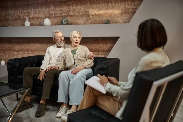 Bärtiger Mann umarmt besorgte Frau mittleren Alters während Therapiesitzung mit Familienberater — Stockfoto