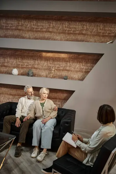 Bärtiger Mann umarmt besorgte Frau mittleren Alters während Therapiesitzung mit Familienberater — Stockfoto