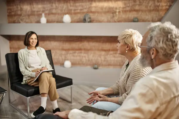 Fokus auf blonde Frau mittleren Alters, die während der Sitzung mit Psychologen spricht und neben ihrem Mann sitzt — Stockfoto