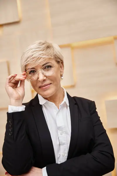 Happy blonde middle aged realtor in eyeglasses working in real estate office, looking at camera — Stock Photo