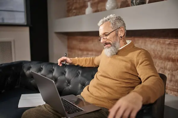Middle aged psychologist with beard talking to client during online consultation on laptop — Stock Photo
