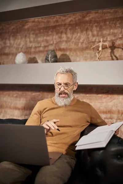 Psychologe mittleren Alters mit Bart spricht während der Online-Beratung am Laptop mit Klient — Stockfoto
