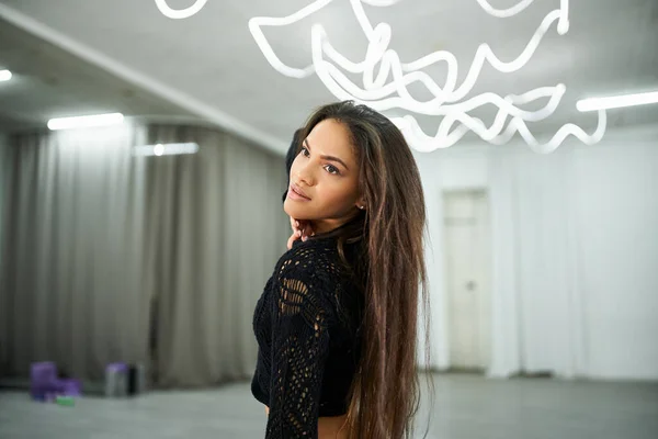 Graciosa dançarina afro-americana de cabelos longos em camisola preta ensaiando no estúdio de dança — Fotografia de Stock