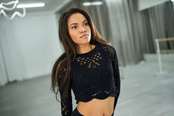 Youthful african american dancer looking at camera while rehearsing in modern dance studio — Stock Photo