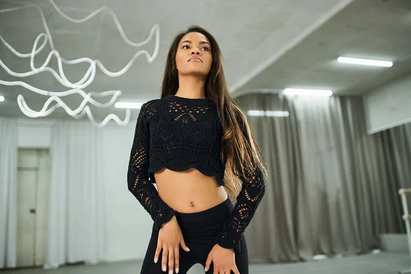 Attractive african american dancer in black knitted sweater rehearsing in dance hall, choreography — Stock Photo