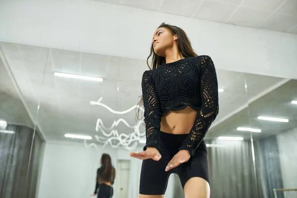 Young energetic african american woman in black attire dancing in studio, modern choreography — Stock Photo
