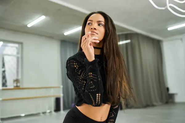 Attractive african american dancer in black attire rehearsing in dance studio, rhythmic movement — Stock Photo