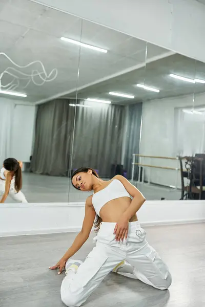 Flexible african american dancer in white sportswear rehearsing on floor in studio, choreography — Stock Photo