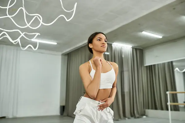 Graceful african american dancer in black crop sweater rehearsing in dance hall, horizontal banner — Stock Photo
