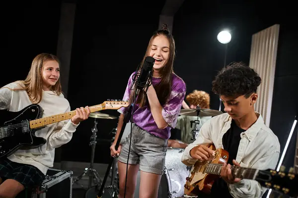 Cheerful adorable teenage band members singing and playing various instruments, musical group — Stock Photo