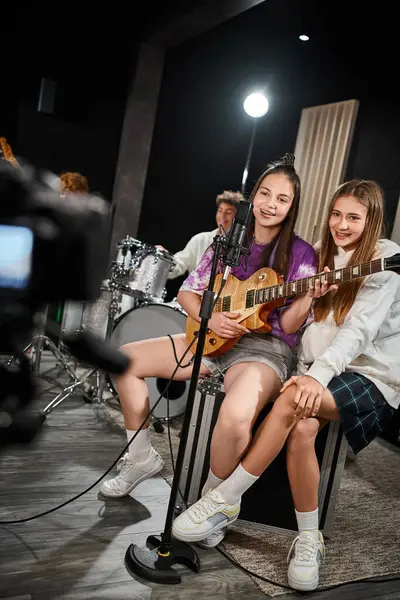 Adolescentes adoráveis alegres cantando e tocando vários instrumentos em estúdio, grupo musical — Fotografia de Stock