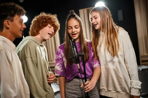 Joyful cute teens in casual attires singing together and smiling happily in studio, musical group — Stock Photo