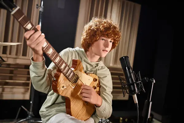 Rojo pelo adorable adolescente en traje casual tocando la guitarra y cantando en el micrófono - foto de stock