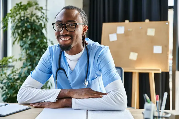 Красивий веселий афроамериканський лікар в окулярах дивиться на камеру під час онлайн-консультації — стокове фото