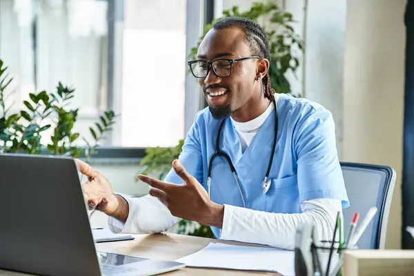 Young happy african american doctor with glasses consulting someone by phone and gesturing actively — Stock Photo