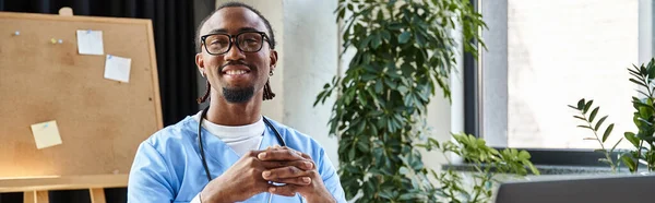 Médecin afro-américain joyeux avec stéthoscope et lunettes souriant et regardant la caméra, bannière — Photo de stock