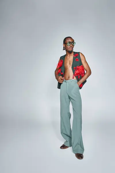Appealing african american man in stylish vest with red tulle fabric looking away, fashion concept — Stock Photo