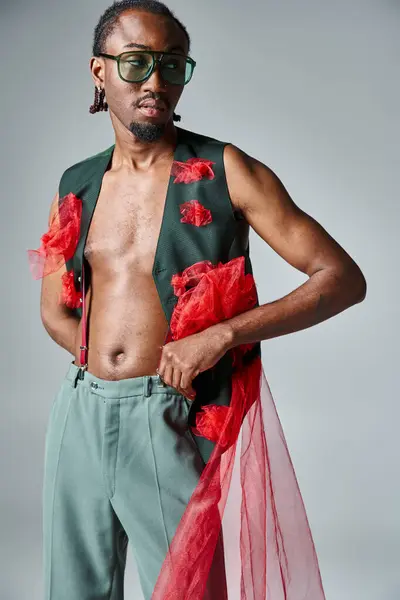 Attractive african american man in stylish vest with red tulle fabric looking away, fashion concept — Stock Photo
