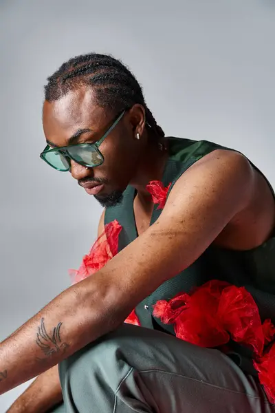 Atractivo hombre afroamericano en traje elegante en cuclillas sobre fondo gris, concepto de moda - foto de stock