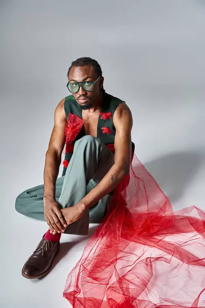 Добре виглядає афро-американська чоловіча модель з сонцезахисними окулярами в модному вбранні, сидячи на підлозі — стокове фото