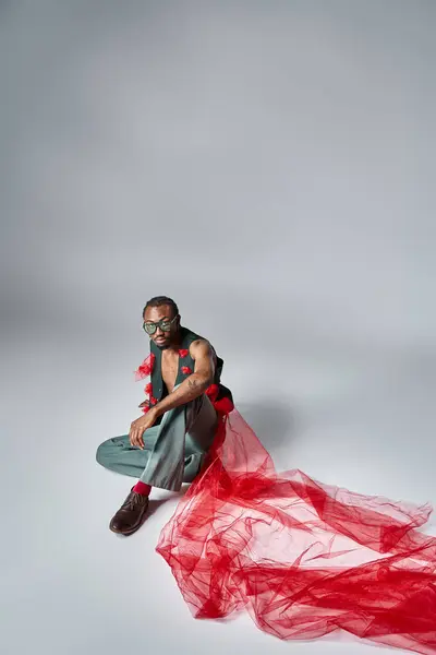 Guapo afroamericano modelo masculino con gafas de sol en traje de moda sentado en el suelo - foto de stock
