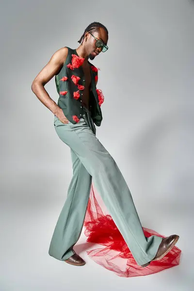 Elegant african american male model with red tulle fabric posing in motion and looking away — Stock Photo