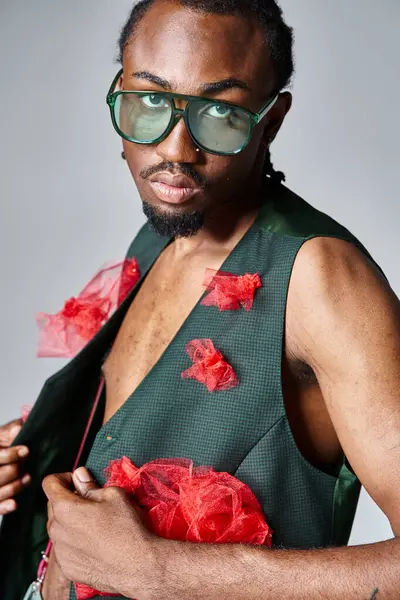 Стильний і молодий афроамериканський чоловік з сонцезахисними окулярами позує в русі і дивиться на камеру — стокове фото