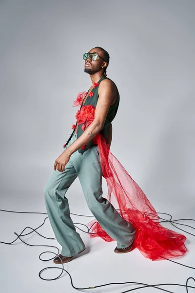 Добре виглядає афроамериканська чоловіча модель з червоною тканиною тканини тканини позує в русі і дивиться в сторону — стокове фото