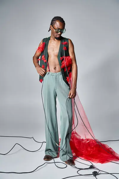 Handsome african american male model with red tulle fabric posing in motion and looking away — Stock Photo