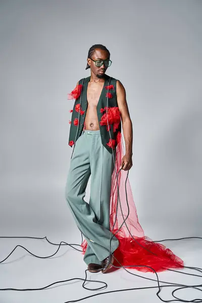 Привлекательная африканская американская модель с красной тканью тюля, позирующей в движении и отводящей взгляд — стоковое фото