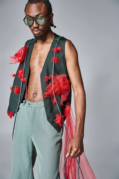 Alluring african american male model with red tulle fabric posing in motion and looking away — Stock Photo