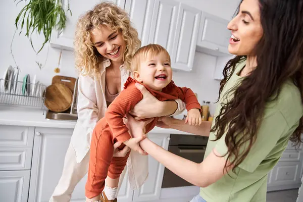 Atractiva pareja lésbica alegre pasar tiempo junto con su hija pequeña, crianza moderna - foto de stock