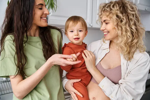 Пов'язана весела лесбіянка пара в домашньому одязі позує щасливо зі своєю дитиною, сучасне батьківство — стокове фото
