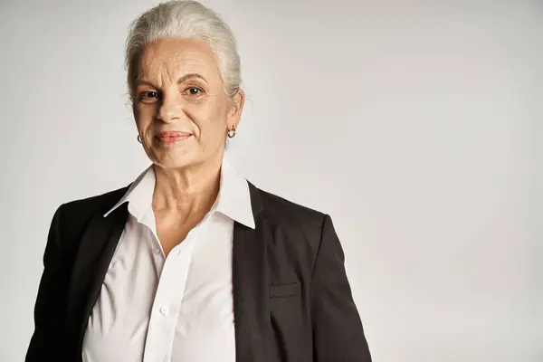 Business portrait of happy middle aged businesswoman in white shirt and blazer looking at camera — Stock Photo